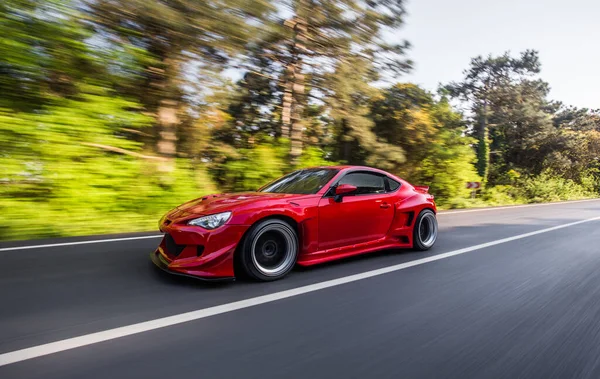 Superpower červené závodní auto na krajině projíždět deštnými pralesy, úhel pohledu — Stock fotografie