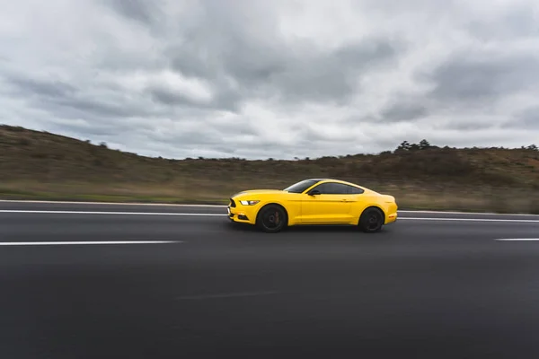 多云天气下，赛车场上的黄色跑车覆盖了整个风景 — 图库照片