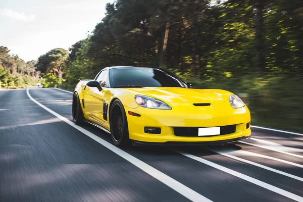 Carro de corrida amarelo com luzes de xenônio vermelho, corrida da floresta — Fotografia de Stock