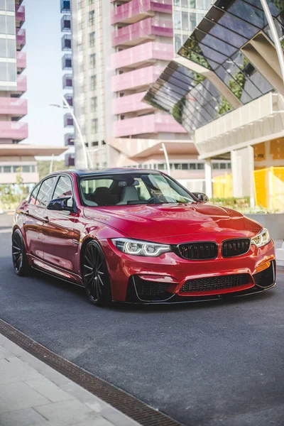 Kırmızı evrensel sedan, zengin mahallelerde, şehir sokaklarında turluyor.