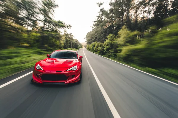 Superpotencia coche de carreras rojo en la unidad de paisaje —  Fotos de Stock