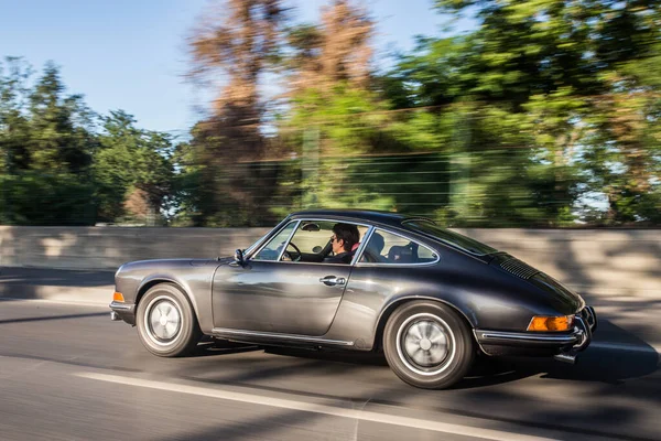 Güneşli bir günde ormanda koşuşturan klasik spor coupe. — Stok fotoğraf