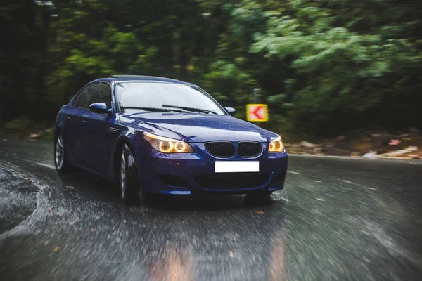 Blue sedan in the nordic forest on a rainy day — Stock Photo, Image