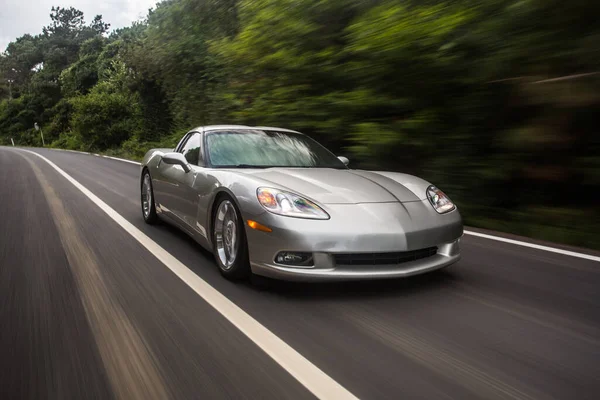 Desempenho de velocidade de supercarro de prata na estrada da floresta no crepúsculo — Fotografia de Stock