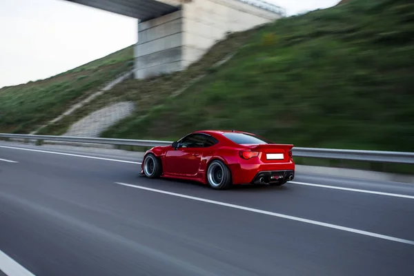 Czerwony elegancki sport samochodowy krajobraz jazdy przez mosty — Zdjęcie stockowe