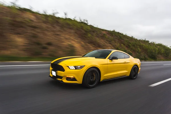Yellow turbocar motion speed test in the highlands,black stripe on it — Stock Photo, Image