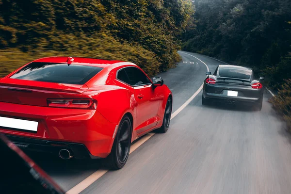Czerwone i czarne samochody sportowe przejeżdżające obok siebie, prędkość jazdy — Zdjęcie stockowe