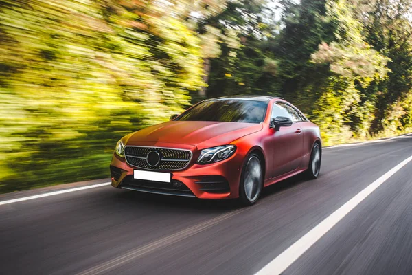 Auto cromata rossa sulla guida all'aperto in autunno — Foto Stock