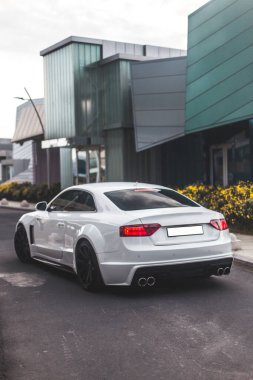 Ticari alanda beyaz spor sedan, arkadan görüş