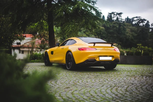 Gele supercar op de parking in een groen park — Stockfoto