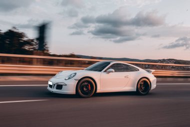 Beyaz spor sedan peyzaj sürücüsü, bulanık arka plan