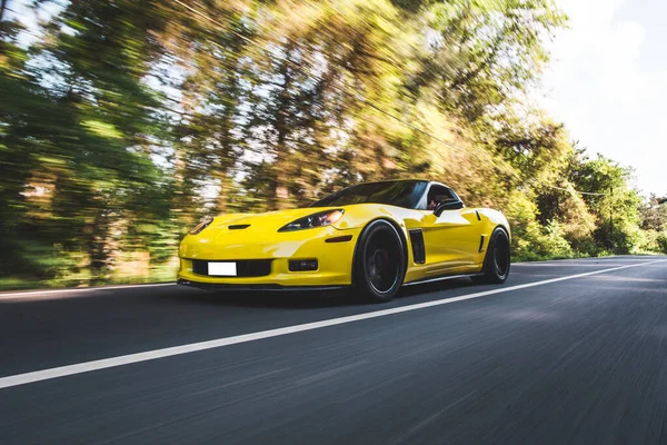 Yellow chrome design car in the forest in a sunlight — Stock Photo, Image