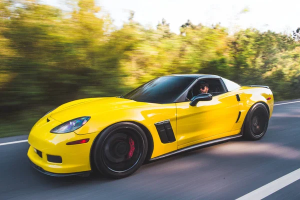 Carro esporte amarelo com autotuning preto na estrada — Fotografia de Stock