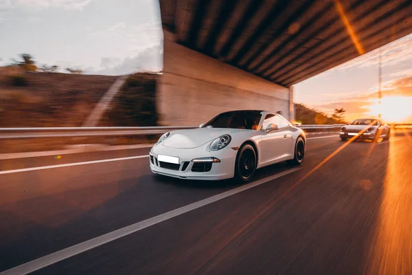 Weiße Sportlimousine auf der Autobahn unter der Brücke — Stockfoto