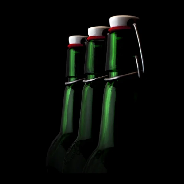 Old fasion green bottles on a black background — Stock Photo, Image