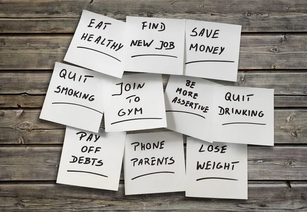 New Year resolutions on pieces of paper — Stock Photo, Image