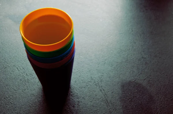 Ensemble de tasses colorées sur la table noire — Photo