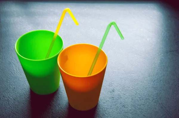 Two cups with the tube on the black background — Stock Photo, Image