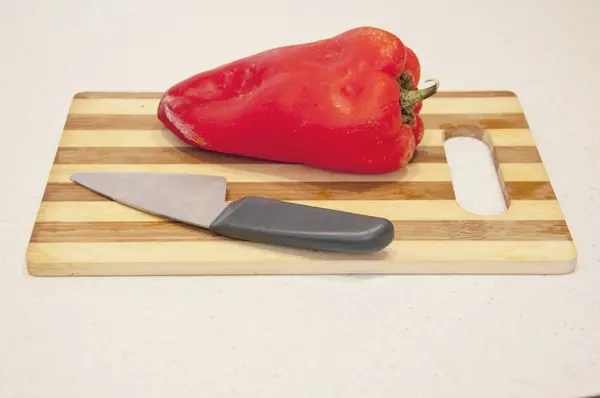Poivron rouge et couteau sur la table — Photo