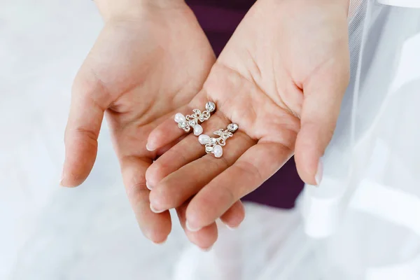 Pendientes en las manos de la novia . — Foto de Stock