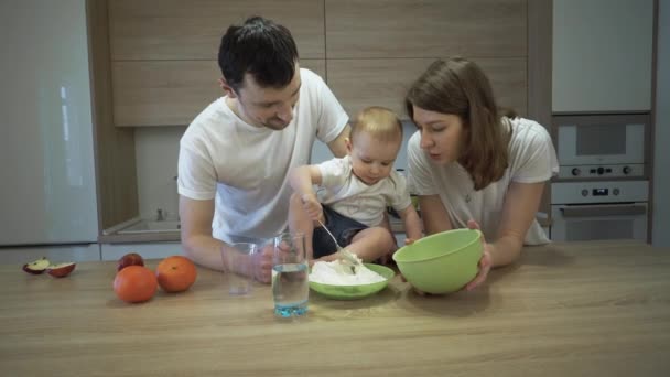 Ebeveynler ve küçük bir kızı evdeki mutfakta yemek pişiriyorlar. Aile mutluluğu kavramı — Stok video