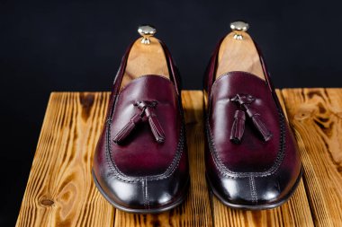 Modern Bordeaux renkleri siyah arkaplan üzerine erkek mokasenleri.