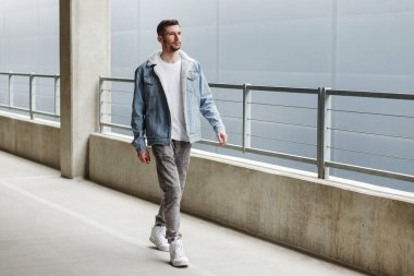 Havalı adam otoparkta yürüyor.