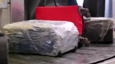 Bagaj atlıkarıncası. Bagajlar, bavullar ve diğer valizler bir havaalanının bagaj teslim alanındaki taşıma bandında taşınır..