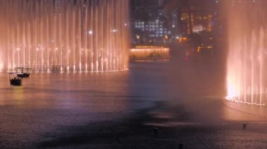 Dubai, Uae - 10 Aralık 2019: İnsanlar geleneksel Abra teknesinde yüzüyor ve Dubai Çeşmesi 'nin tadını çıkarıyorlar..
