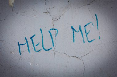 Şehir sokakları, kirli eski duvardaki bana yardım metni