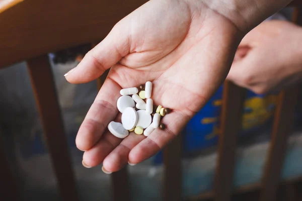 Tabletten in der Hand einer Frau und ein Glas reinen Wassers. Medizinkonzept — Stockfoto