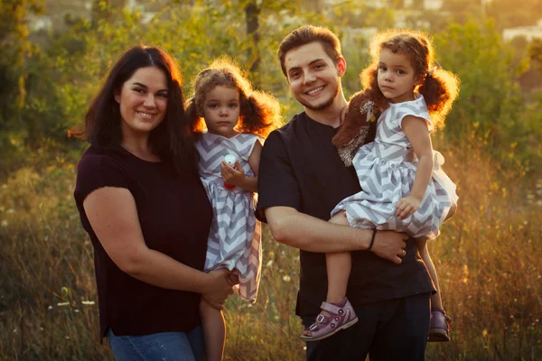 Dört küçük kızlar twins ile sonbahar orman Park aile portresi. Mutlu insanlar, gülümseyen ve öpüşme. Sıcak akşam güneş ışığı