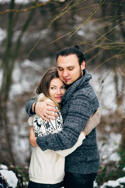 Çift eğlence ve kahkaha var. öpücük. Genç hippi çift birbirlerine kış parkta sarılma. Kış aşk hikayesi, güzel, şık, genç bir çift. Kış moda kavramı erkek ve kız arkadaşı ile.