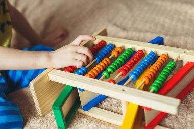 Küçük çocuk abaküs ile oynarken el. Clouse tahta oyuncakla oynamak kıvırcık şirin bebek fotoğrafı. Çocuk eğitim