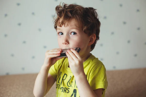 Kleine jongen met de mondharmonica. Onderwijs concept. Muziek concept — Stockfoto