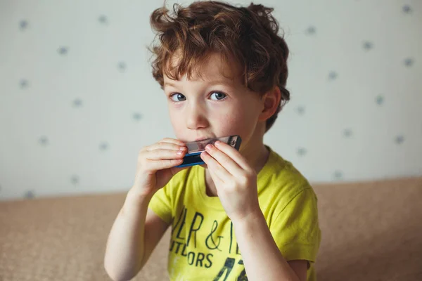 Kleiner Junge mit der Mundharmonika. Bildungskonzept. Musikkonzept — Stockfoto