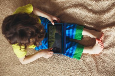 Tablet bir yatak üzerinde kullanma küçük çocuk. Üstten Görünüm