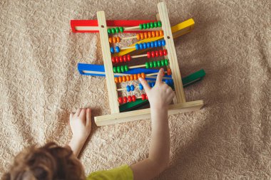 Okul öncesi bebek saymak öğrenir. Şirin çocuk abaküs oyuncakla oynamak. Küçük çocuk kapalı evde eğlenmek, anaokulu veya gündüz bakım merkezi. Okul öncesi çocuklar için eğitim kavramı.