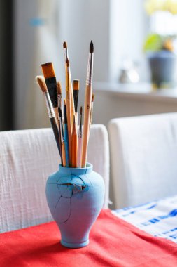 Bir tablo üzerinde Boya fırçaları. Dikey fotoğraf. Sanatçı workshop.