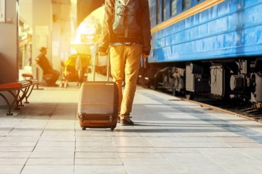 Seyahat kavramı. Erkek spor ayakkabı ayakkabı giymek ve tren istasyonunda Bagaj ile seyahat.