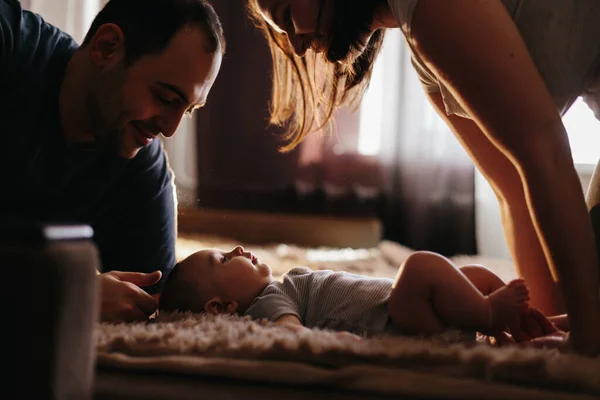 Dziecko z rodzicami bawiącymi się na łóżku. Szczęśliwa rodzina w domu. Styl życia przytulne zdjęcia. Mały chłopiec 4 miesiące — Zdjęcie stockowe
