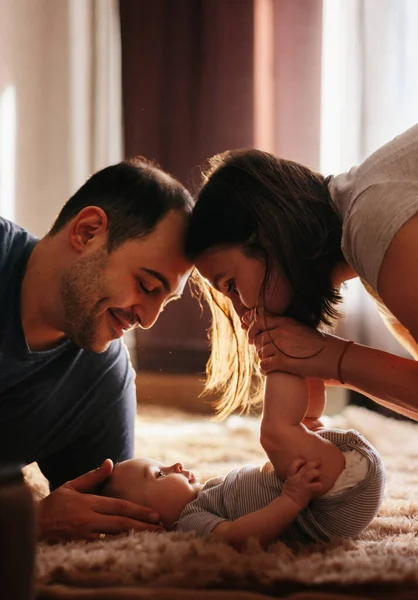 Anne babasıyla yatakta oynayan bir bebek. Evde mutlu bir aile. Hayat tarzı rahat fotoğraflar. Küçük çocuk 4 aylık. — Stok fotoğraf