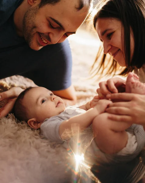 Baby met zijn ouders die op het bed spelen. Gelukkig gezin thuis. Lifestyle gezellige foto 's. Kleine jongen 4 maanden oud — Stockfoto