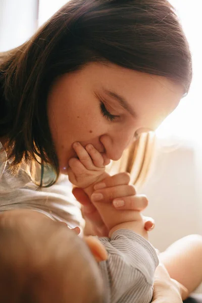 妈妈吻着她的小儿子的一只手. 爱的情感家庭 — 图库照片