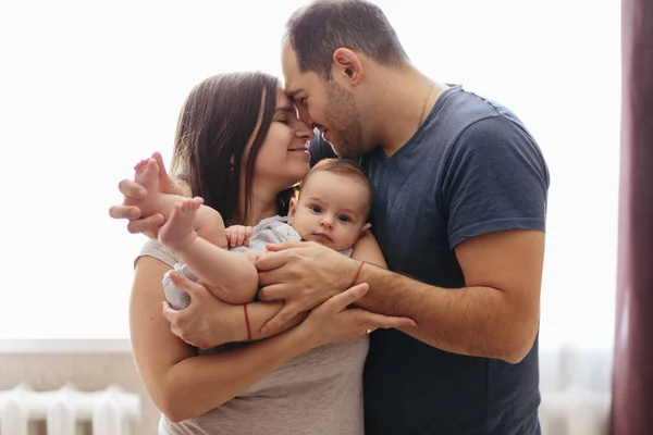 Bebé con sus padres jugando en la cama. Familia feliz en casa. Estilo de vida fotos acogedoras. Niño pequeño de 4 meses — Foto de Stock