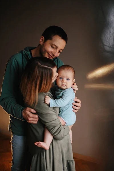 Retrato de una joven familia feliz con el niño. Hermosos abrazos familiares — Foto de Stock