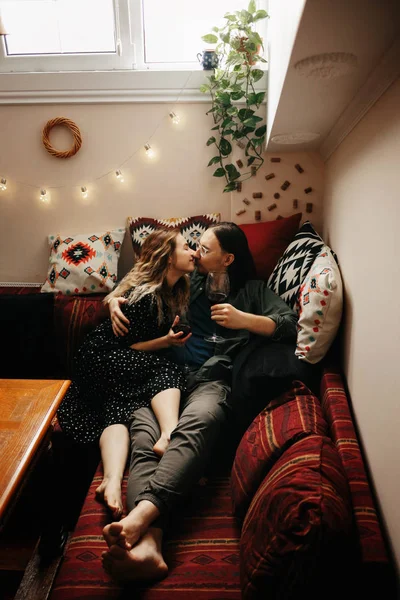 Romantic couple having dinner at home. Man pouring wine. Beautiful cozy interior — Stock Photo, Image