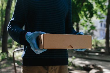 Market teslimatçısı COVID-19 Coronavirus sorunu için mavi eldiven takıyor.