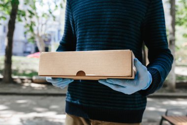 Market teslimatçısı COVID-19 Coronavirus sorunu için mavi eldiven takıyor.