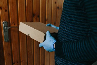 Market teslimatçısı COVID-19 Coronavirus sorunu için mavi eldiven takıyor.